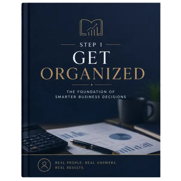 Book cover: 'Step 1: Get Organized' with gold letters on navy background and business charts on the desk foreground.